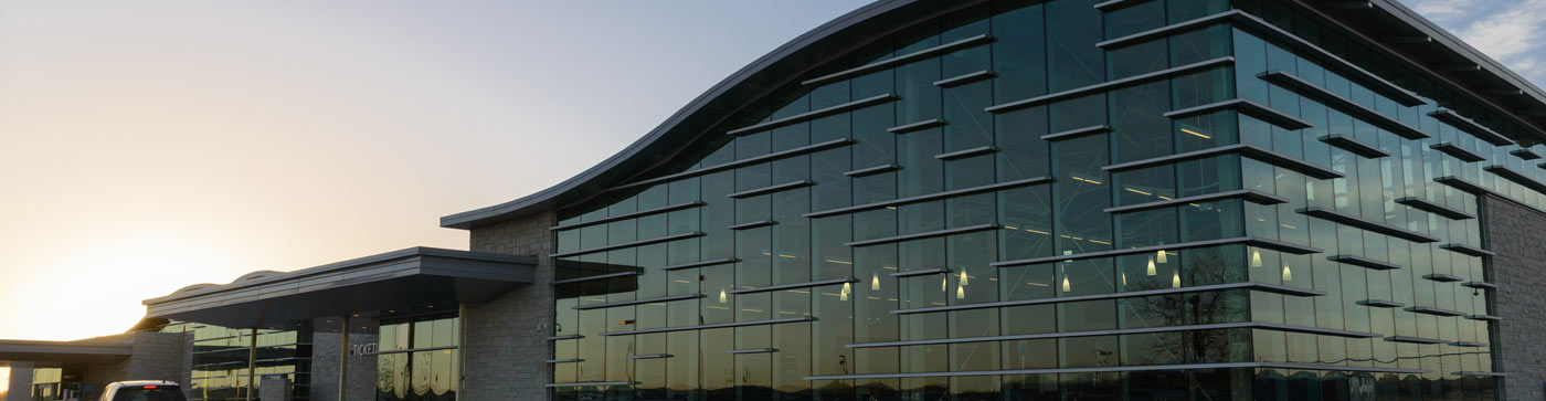 large modern glass building at sunset